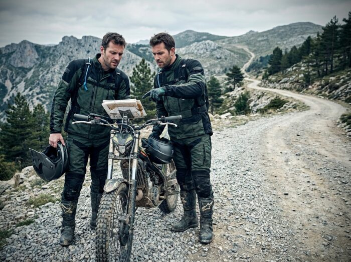 Two beginner riders in trial consulting a roadbook on a mountain path, navigation error in trial motorcycle riding